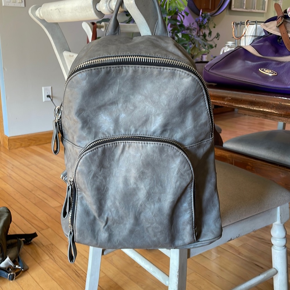 Grey leather back pack with silver zippers
